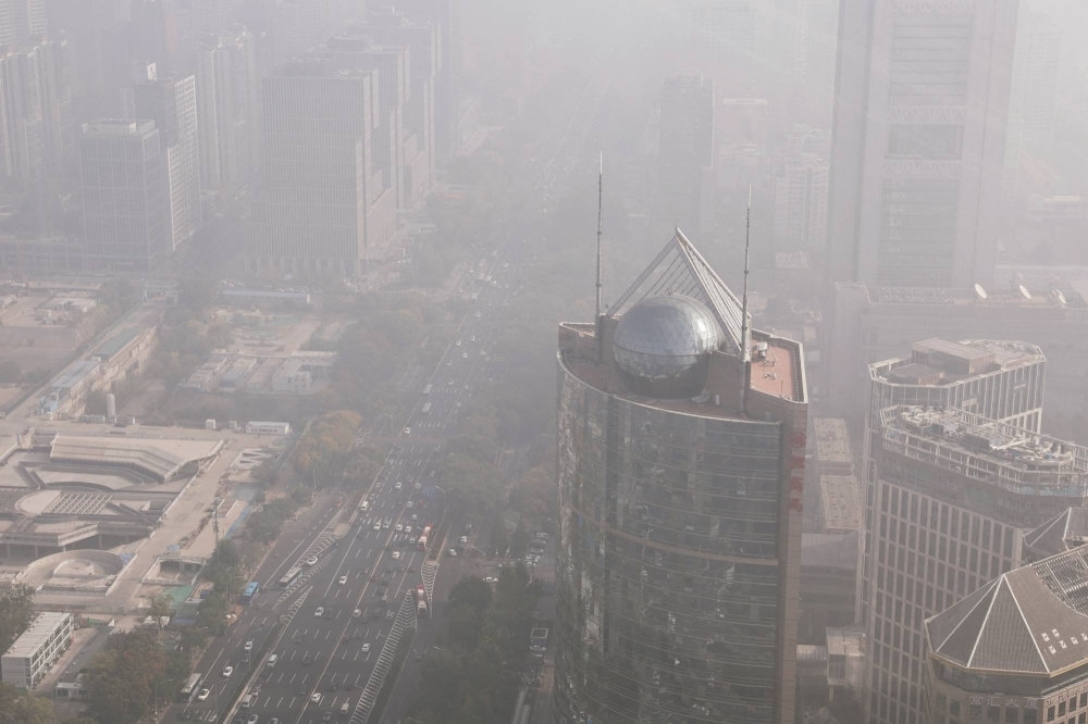 Cars move on a street in Beijing's Central Business District as the city is shrouded in smog on Wednesday.