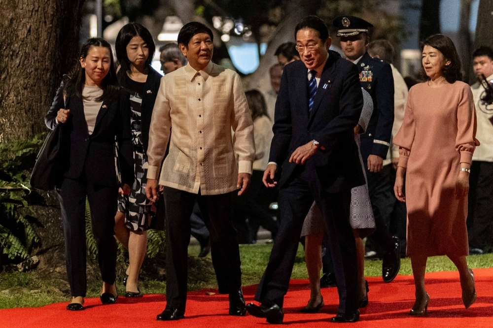 Prime Minister Fumio Kishida and Philippines President Ferdinand Marcos Jr. review an honor guard during a welcome ceremony in Manila on Friday. 
