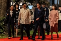Prime Minister Fumio Kishida and Philippines President Ferdinand Marcos Jr. review an honor guard during a welcome ceremony in Manila on Friday.  | Pool / via AFP-JIJI