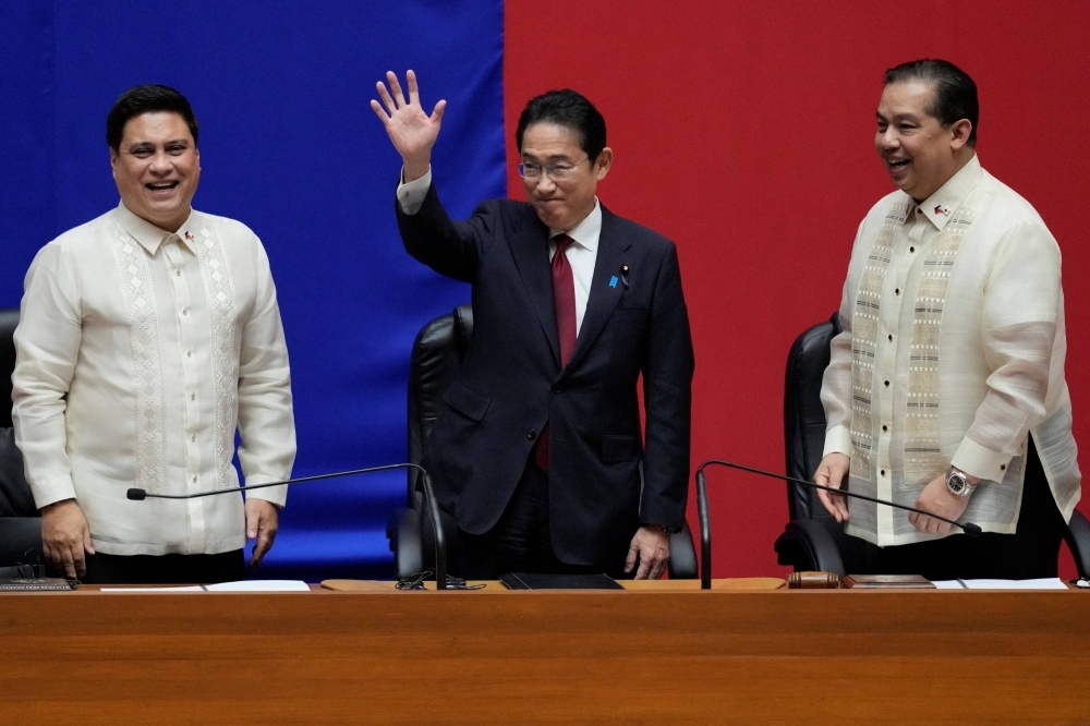 Prime Minister Fumio Kishida, the first Japanese leader to address a special joint session of the Philippine Congress, waves beside Philippines' Senate President Juan Miguel Zubiri and Philippines' House Speaker Martin Romualdez at the House of Representatives in Quezon City, Philippines, on Saturday.