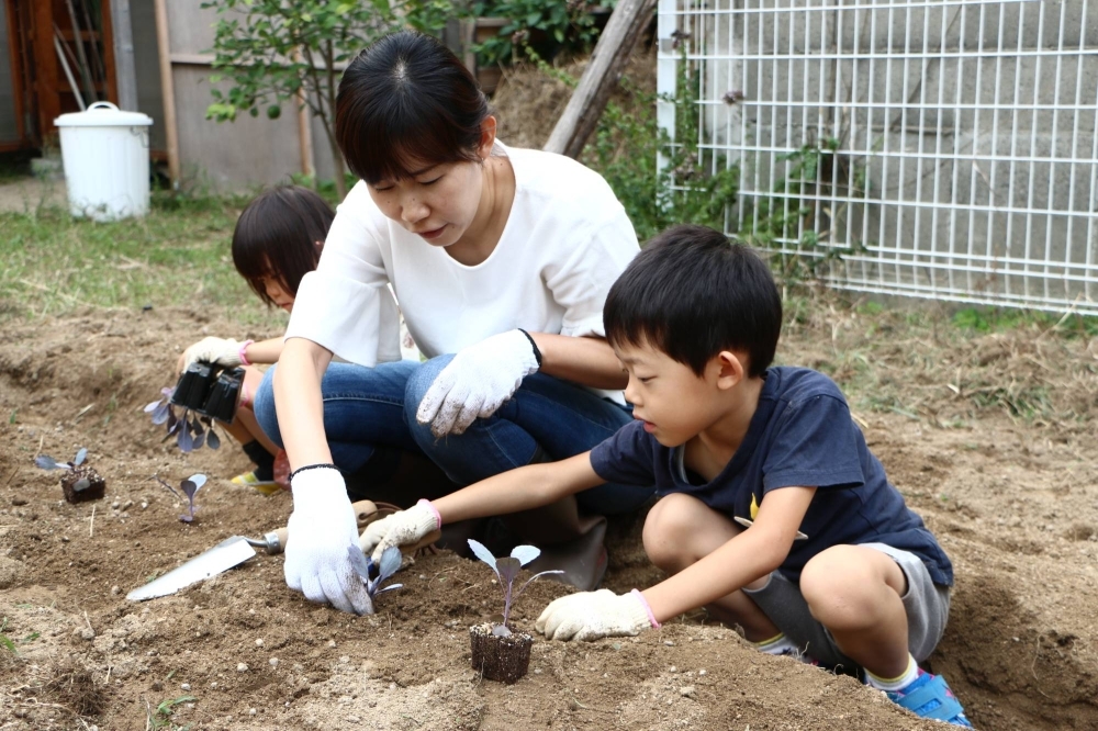 A woman and her children at the Minnanouen Kitakagaya community garden in Osaka's Suminoe Ward
