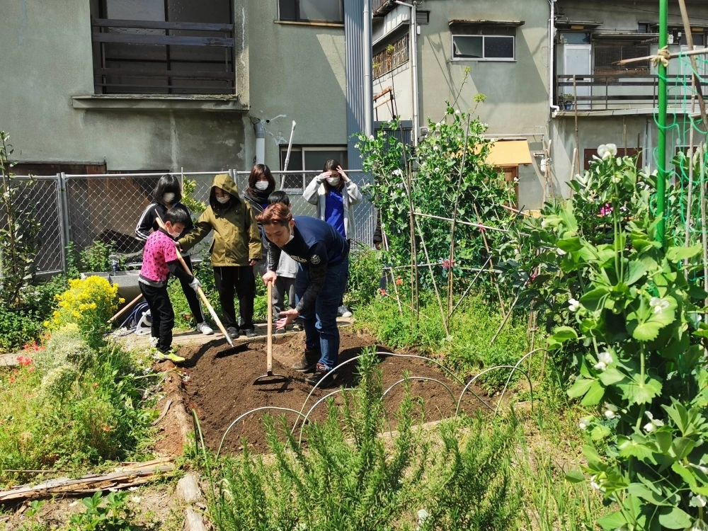 Members of the Minnanouen Kitakagaya community garden cultivate soil. 