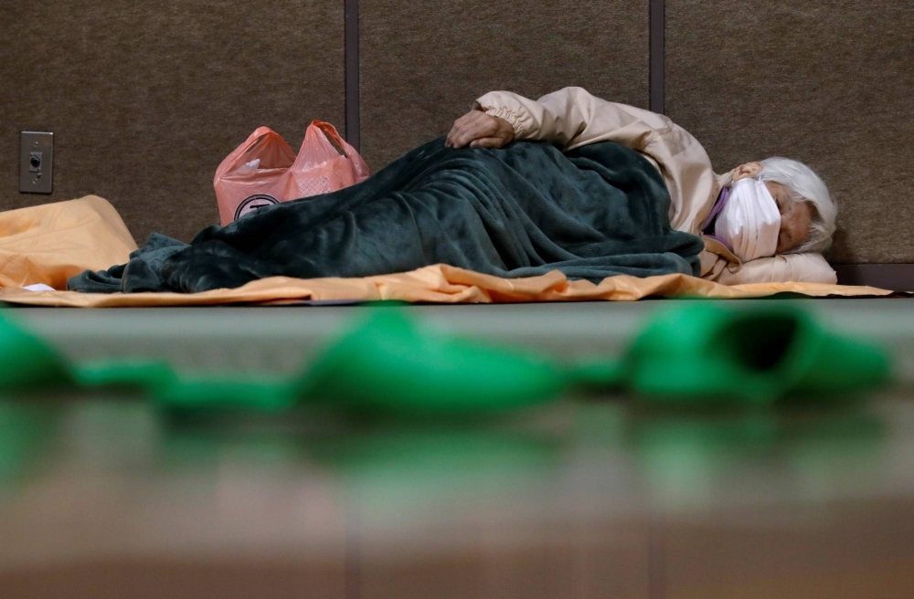 A woman sleeps in an evacuation center for residents affected by flooding following Typhoon Hagibis in Nagano in October 2019.