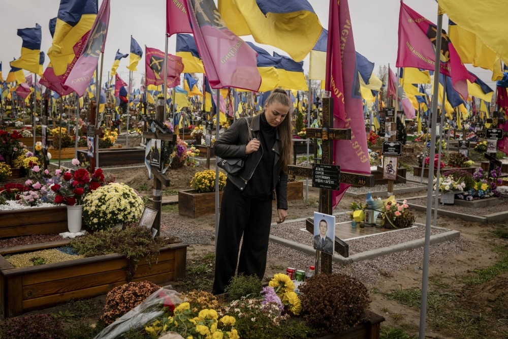 A woman visits the grave of a soldier on the anniversary of his death at a cemetery in Kharkiv, Ukraine, on Oct. 21.