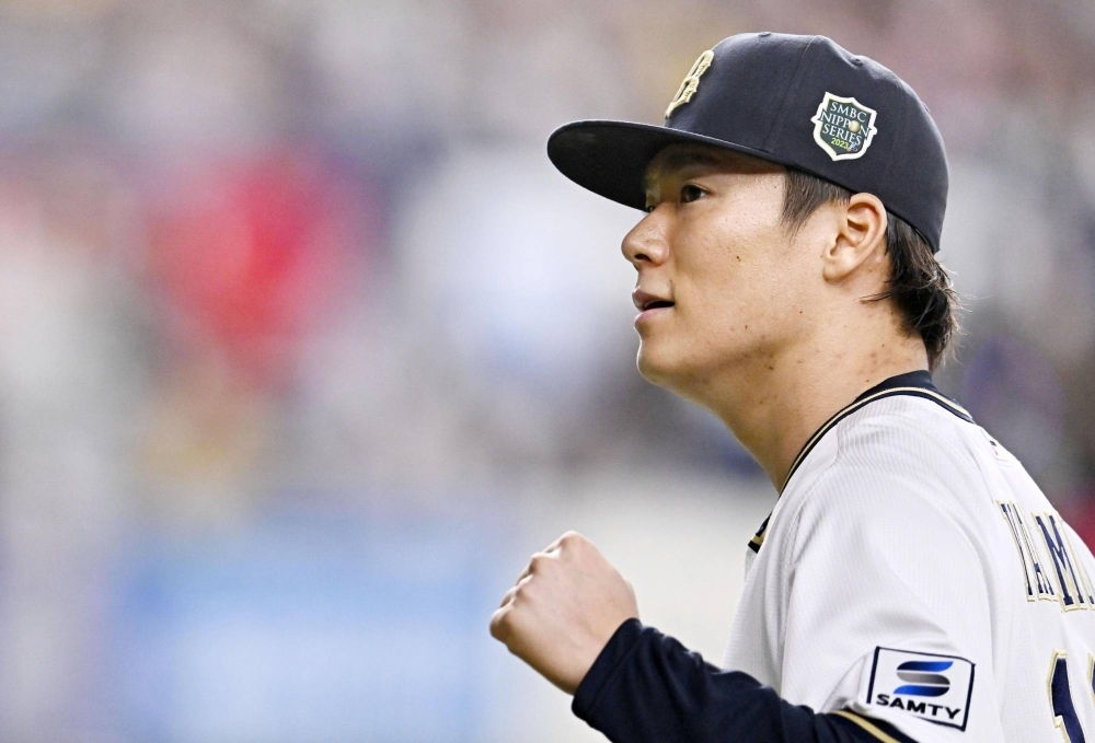 Buffaloes ace Yoshinobu Yamamoto pumps his fist after retiring the side in the 5th inning of his complete game victory over the Hanshin Tigers on Saturday at Kyocera Dome Osaka. 