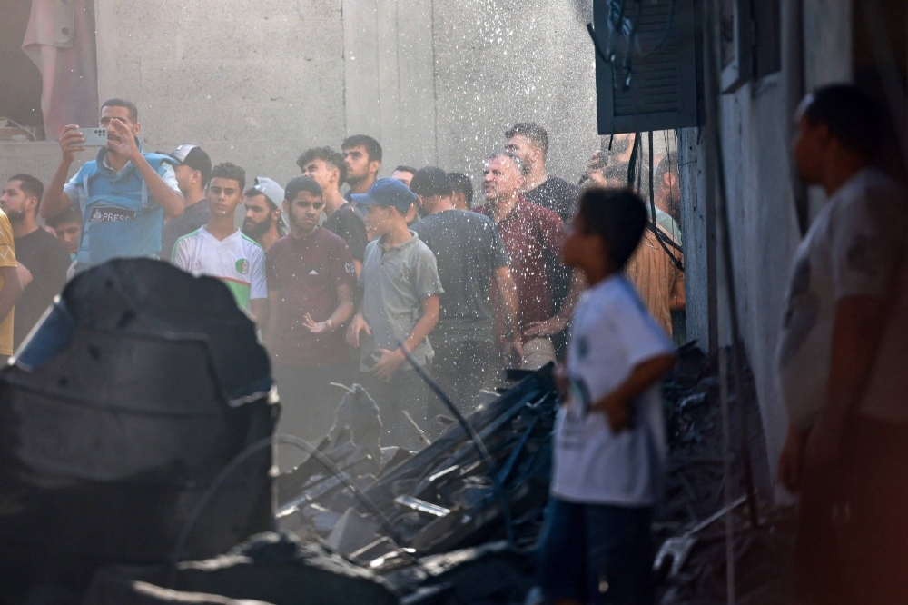 Palestinians gather at the scene of a strike in a refugee camp in the central Gaza Strip on Saturday.