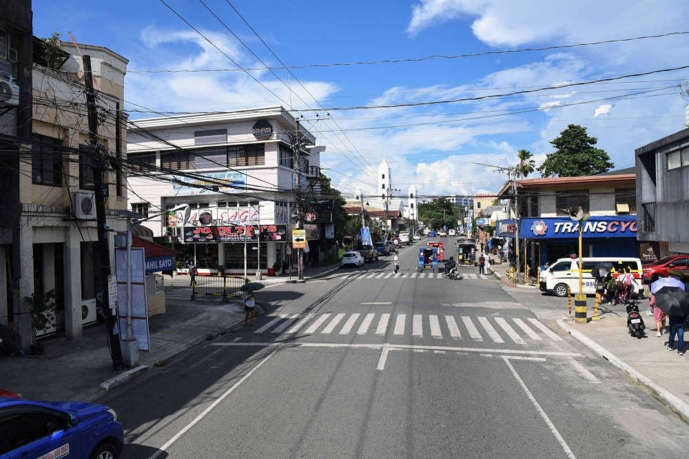 Vehicles and pedestrians by the intersection of Burgos and Real streets in Tacloban city, Leyte province, the Philippines, on Oct. 12.