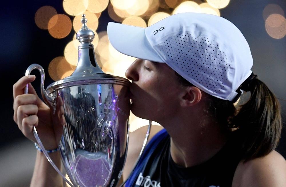 Poland's Iga Swiatek kisses her trophy on the podium after winning the WTA Finals Championship in Cancun, Mexico, on Monday.