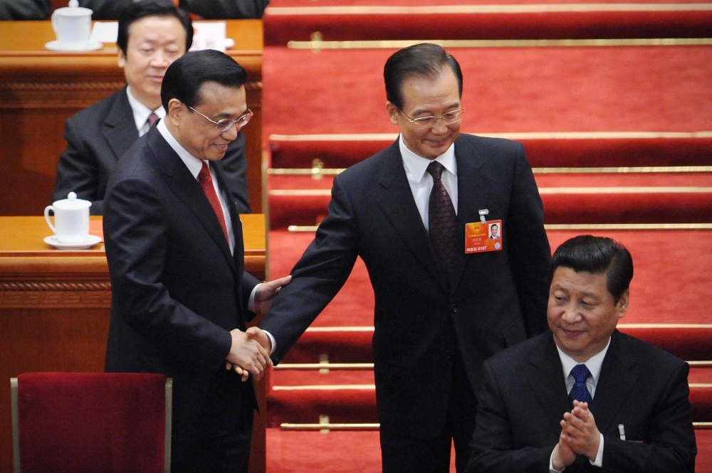 New Chinese Premier Li Keqiang (left) and and his predecessor, Wen Jiabao (center), attend the 12th National People's Congress where Chinese President Xi Jinping was first elected in Beijing in March 2013.