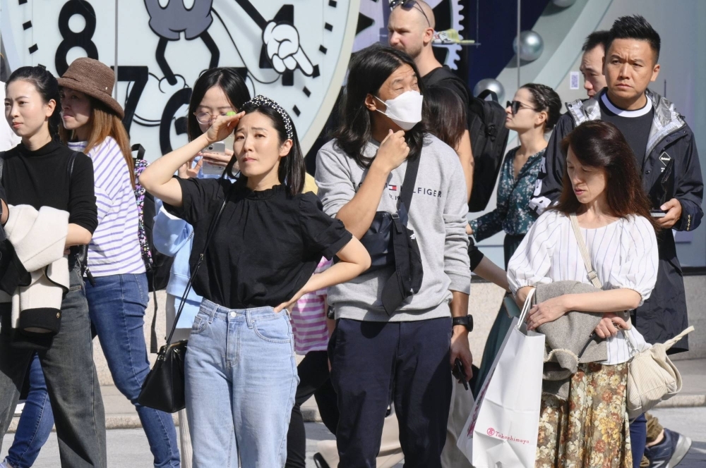 People wear lighter clothes in Tokyo on Saturday amid warm weather. On Tuesday, the capital marked a record high temperature for November. 
