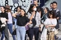 People wear lighter clothes in Tokyo on Saturday amid warm weather. On Tuesday, the capital marked a record high temperature for November.  | Kyodo