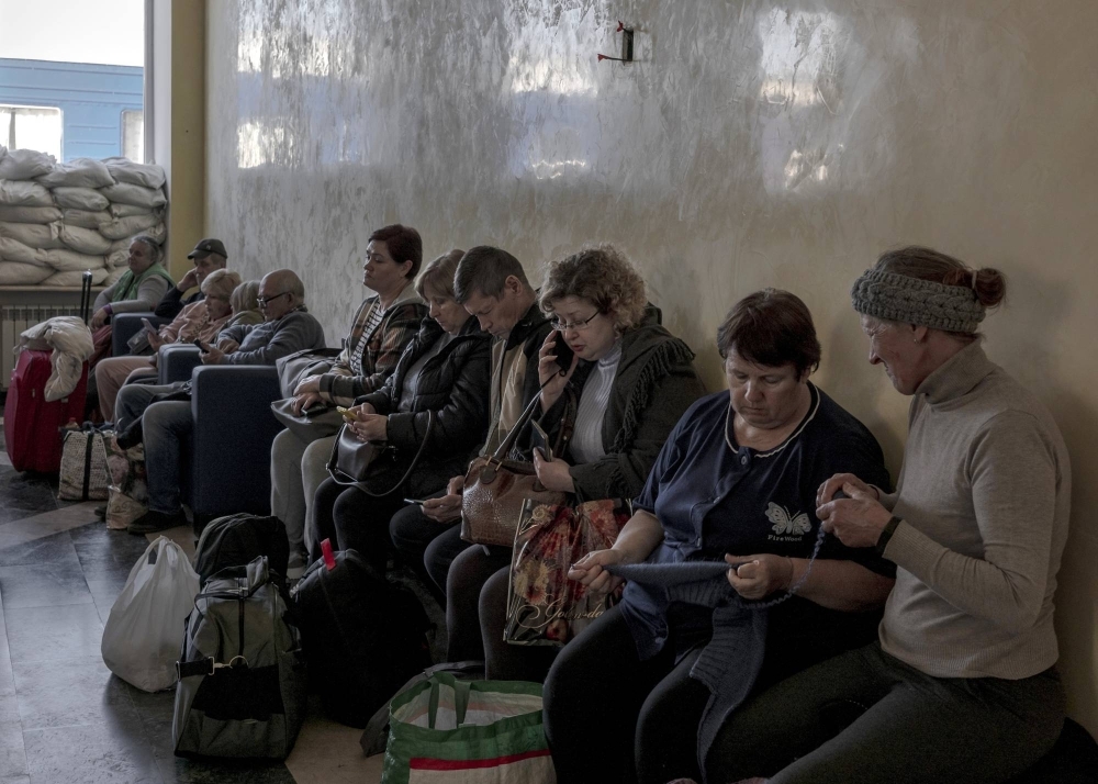 People wait for the arrival of a train going west, in Kherson, Ukraine, on Oct. 31. 