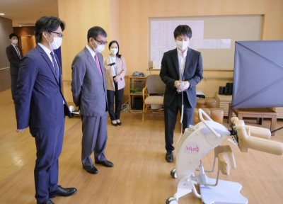 Digital Minister Taro Kono looks at a nursing robot in a day care facility in Tokyo on Oct.18.