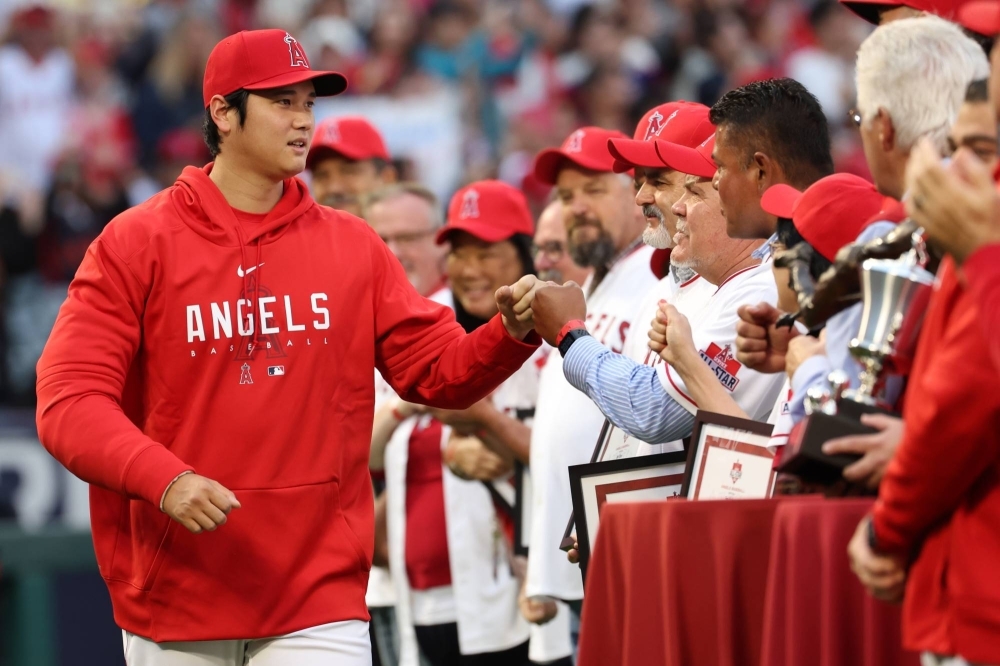 Los Angeles Angels two-way player Shohei Ohtani fist-bumps Angels employees as he heads onto the field to receive the Angels team MVP Award before a game at Angel Stadium in Anaheim, California, on Sept. 30.