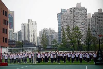 Students stand during a flag-lowering ceremony on the first day of the new academic year in Shanghai in 2021. 