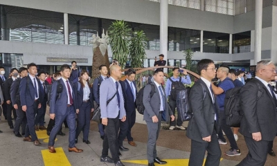 Japanese police investigators arrive at Phnom Penh International Airport on Tuesday.