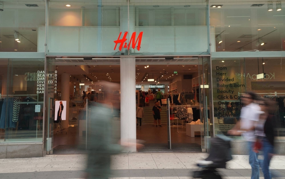 Pedestrians and shoppers walk past a branch of fashion retailer H&M in central Stockholm on July 17.