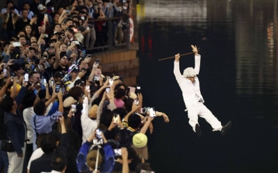 A man dressed as Kentucky Fried Chicken founder Colonel Sanders jumps into the Dotonbori River in Osaka after the Hanshin Tigers won the Japan Series.