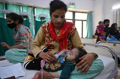 A mother assists her child to breathe with the help of a nebuliser at the emergency ward of the government-run Chacha Nehru Bal Chikitsalaya children hospital in New Delhi on Tuesday.