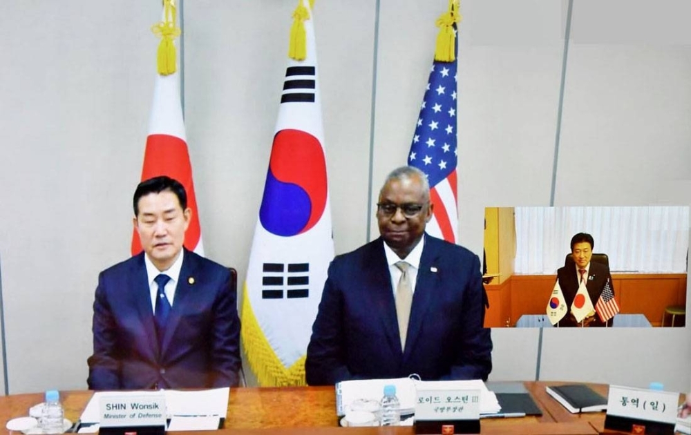 U.S. Defense Secretary Lloyd Austin (center) meets his South Korean counterpart, Shin Won-sik (left), in Seoul on Sunday with Japanese Defense Minister Minoru Kihara joining them online.