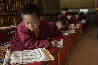 Young monks practice writing Tibetan at a monastery in Yushu, China. Beijing has restricted the teaching and practice of minority languages and religions.