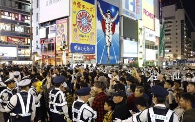 Police try to control the crowd in the city of Osaka after the Hanshin Tigers won the Japan Series baseball championship on Nov. 5. 