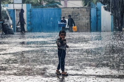A boy stands in the rain at a school run by the United Nations Relief and Works Agency for Palestine Refugees in the Near East in Rafah in the southern Gaza Strip on Tuesday.