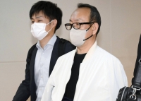 Daisuke Ogawa (right) arrives at Haneda International Airport in Tokyo on Wednesday after being transferred from Thailand. | Kyodo