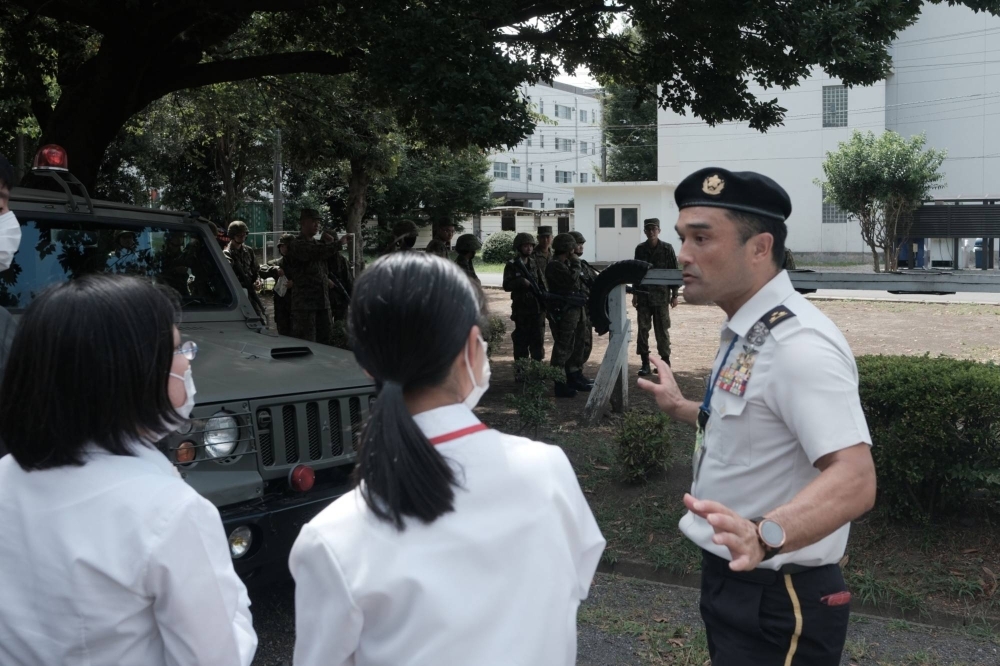 A Self-Defense Forces officer talks to participants in an information session at Camp Nerima in Tokyo on Aug. 7. The SDF raised the maximum age for new recruits to 32 from 26 in 2018 but has still struggled to attract them.