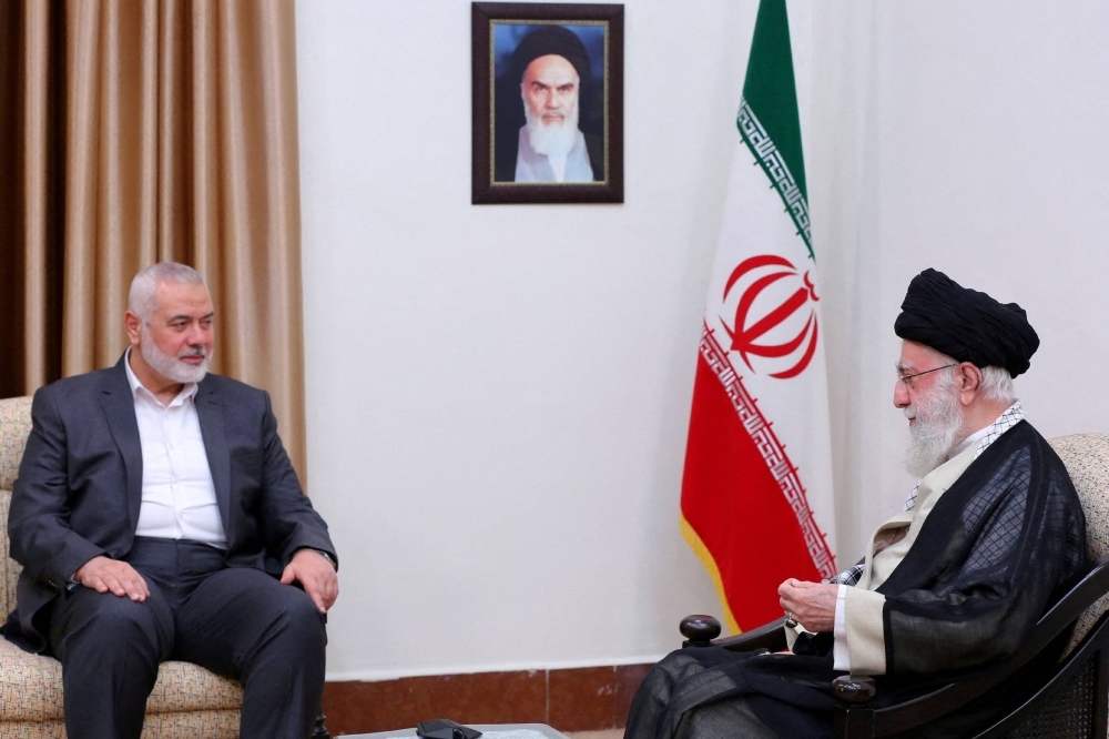 Iranian Supreme Leader Ayatollah Ali Khamenei meets with Hamas' top leader Ismail Haniyeh in Tehran in June. Both men met again in early November during which the former told the latter that Iran would not intervene directly following the Oct. 7 attack on Israel.