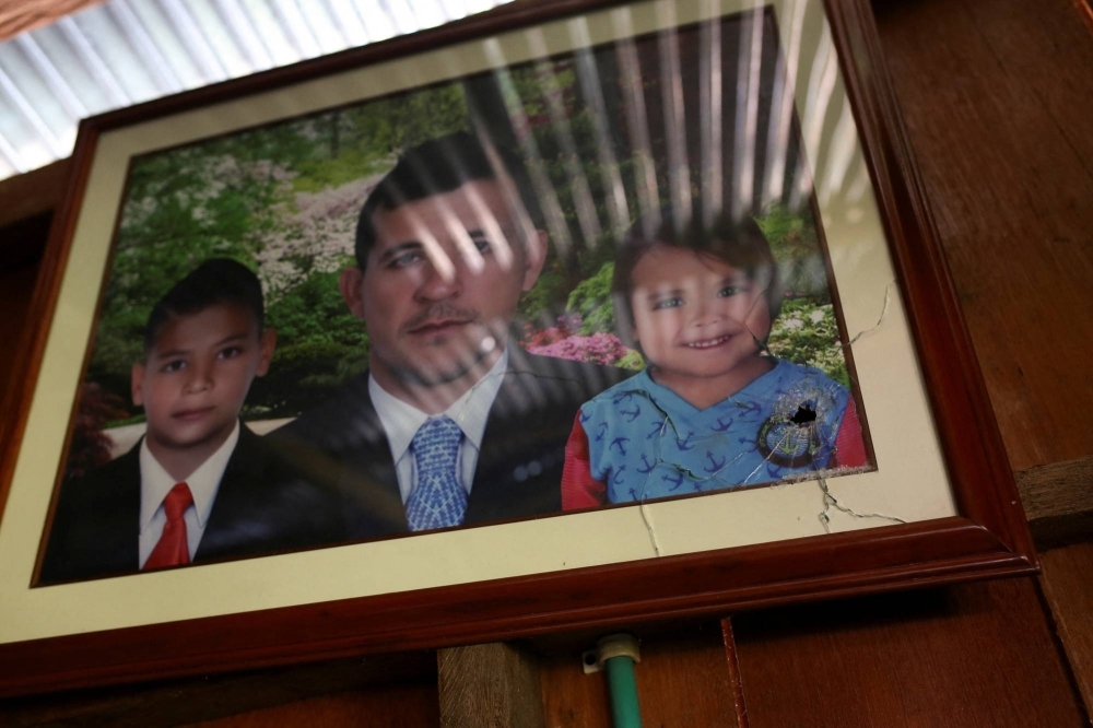 A bullet-pierced photograph of Jorge Santofimio and his children hangs on a wall inside his house in Puerto Guzman, Colombia.