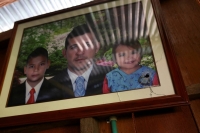 A bullet-pierced photograph of Jorge Santofimio and his children hangs on a wall inside his house in Puerto Guzman, Colombia. | REUTERS