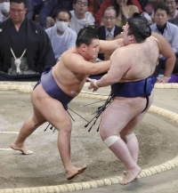Hoshoryu (left) defeats Gonoyama by push out at the Fukuoka Kokusai Center on Thursday. | Kyodo