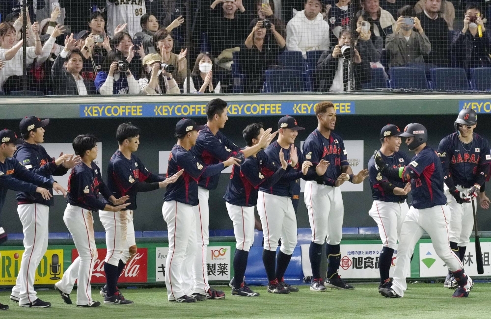 Shota Morishita (second from right) is congratulated by teammates after his home run in the seventh inning against Taiwan during the Asia Professional Baseball Championship at Tokyo Dome on Thursday.