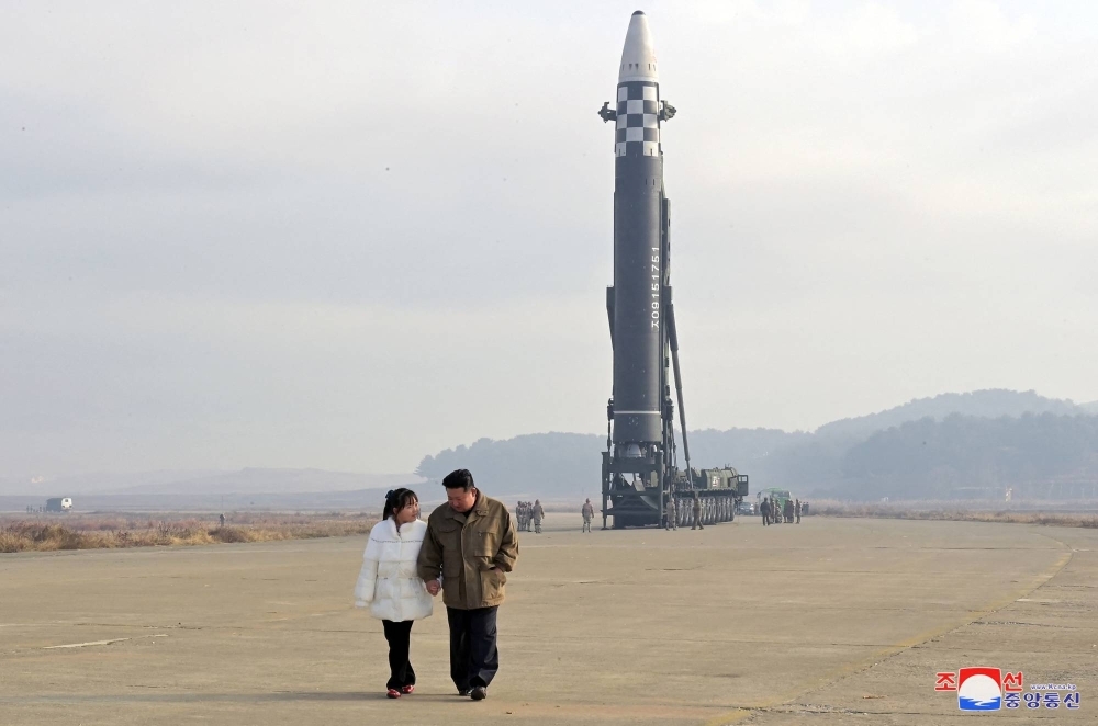 North Korean leader Kim Jong Un, along with his daughter, walks away from an intercontinental ballistic missile in this undated photo released on Nov. 19, 2022 
