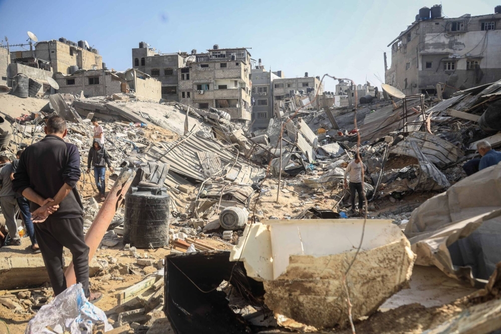 Palestinians amongst the rubble of destroyed residential buildings following Israeli airstrikes in the Shejaiya district east of Gaza City, Gaza, on Nov. 9.