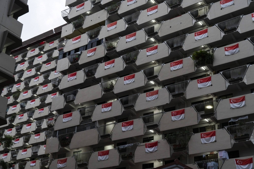 Singapore national flags hang from the facade of a Housing & Development Board public housing estate in the Selegie area of Singapore, in 2021.