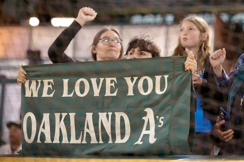 A fan holds a sign during a game between the A's and Rangers in Oakland, California, on Aug. 7.