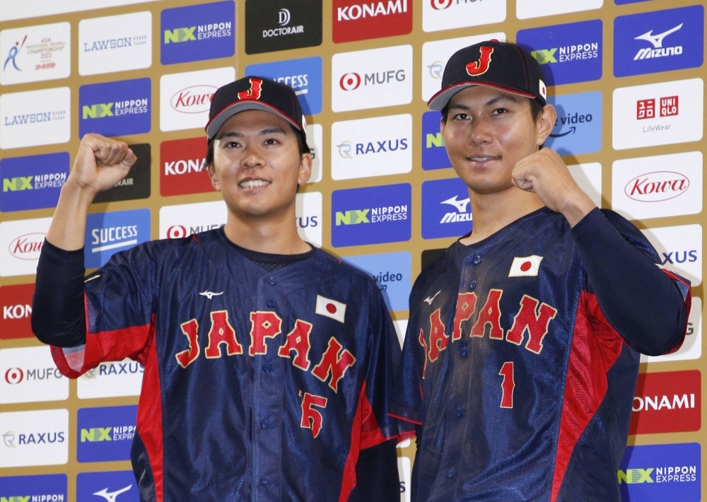 Japan's Takahisa Hayakawa (left) and Kyota Fujiwara pose for photos after their win over Australia at Tokyo Dome on Saturday.