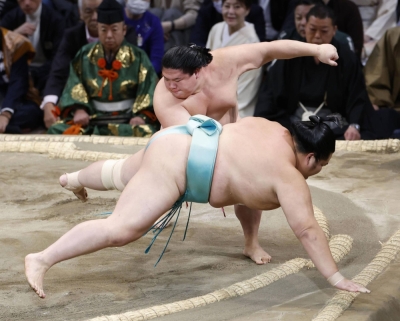 Ura (behind) hands the previously undefeated Kotonowaka his first loss on Saturday in Fukuoka during the Kyushu Grand Sumo Tournament. 