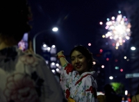A woman wearing yukata at the Sumida River fireworks festival in Tokyo in July.  | Reuters