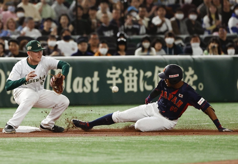 Chusei Mannami slides into third after hitting a triple as Australia third basemen Luke Smith waits for the throw during the teams' Asia Professional Baseball Championship clash on Saturday at Tokyo Dome.  