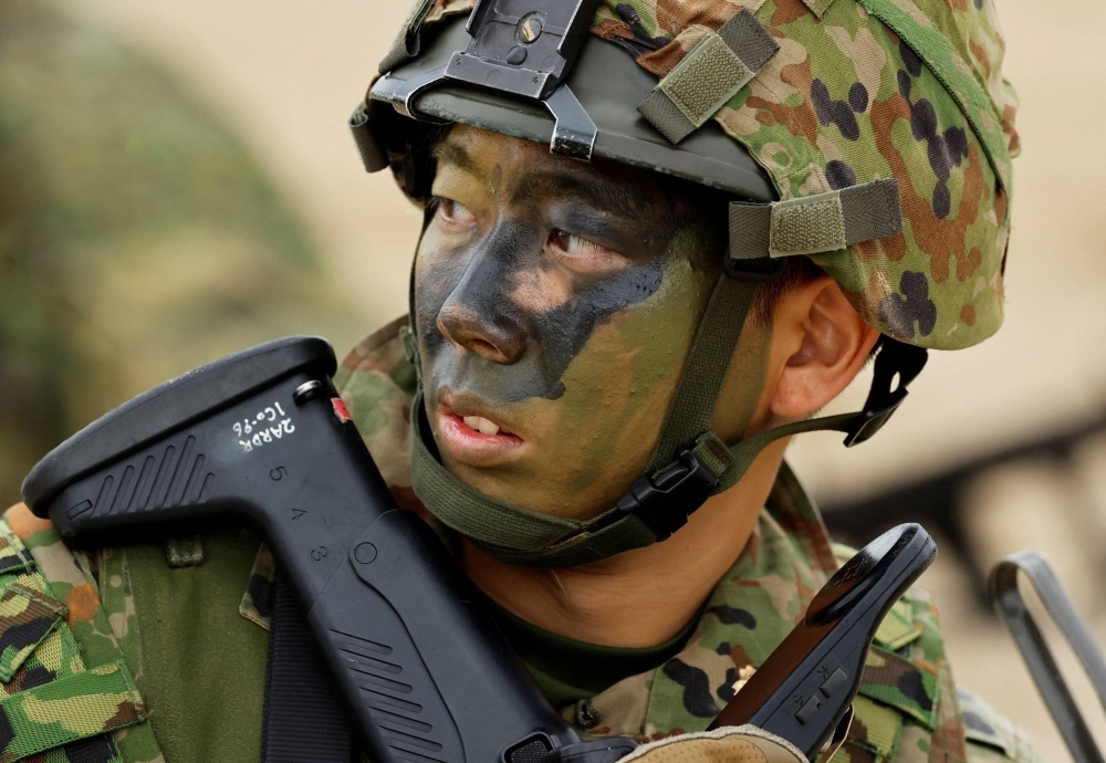A Ground Self-Defense Force marine takes part in a landing drill as a part of the country's nationwide 05JX military exercises on the island of Tokunoshima, in Kagoshima Prefecture, on Sunday.