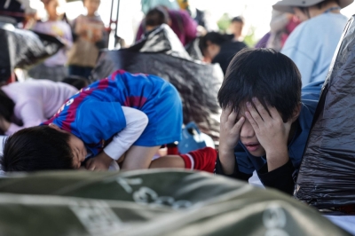 Children take shelter when hearing an air raid sirens during an event held by the Taiwanese civil defense organization Kuma Academy, in New Taipei City on Saturday to raise awareness of natural disaster and war preparedness.