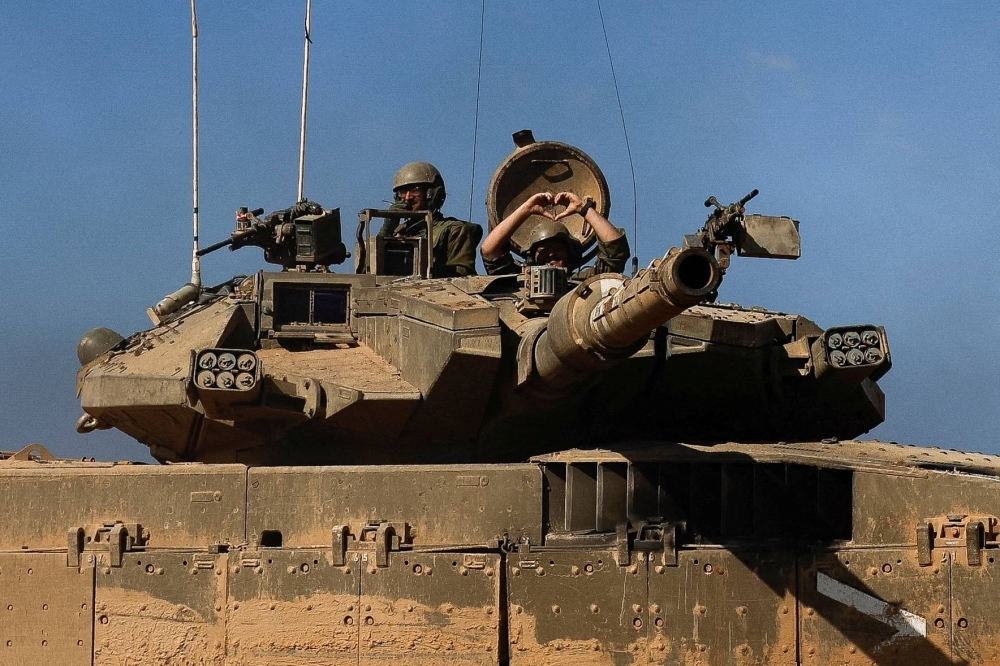 An Israeli soldier gestures from a tank, near a border area with Gaza, in southern Israel, on Thursday.