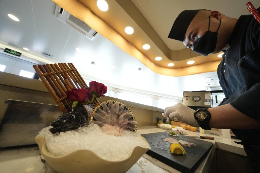 A cook prepares sashimi in China's Shandong Province in August.