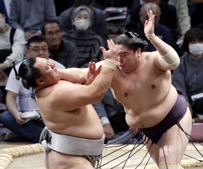 Ichiyamamoto (right) charges Tamawashi during their bout on Day 9 of the Kyushu Grand Sumo Tournament in Fukuoka on Monday
