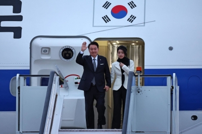 South Korean President Yoon Suk-yeol waves as he and his wife, Kim Keon-hee, arrive in London on Monday for a state visit to the U.K.