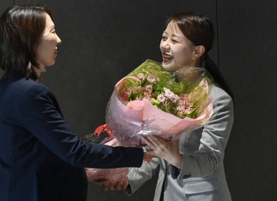 Newly elected Yawata Mayor Shoko Kawata (right) receives flowers at city hall on Thursday.