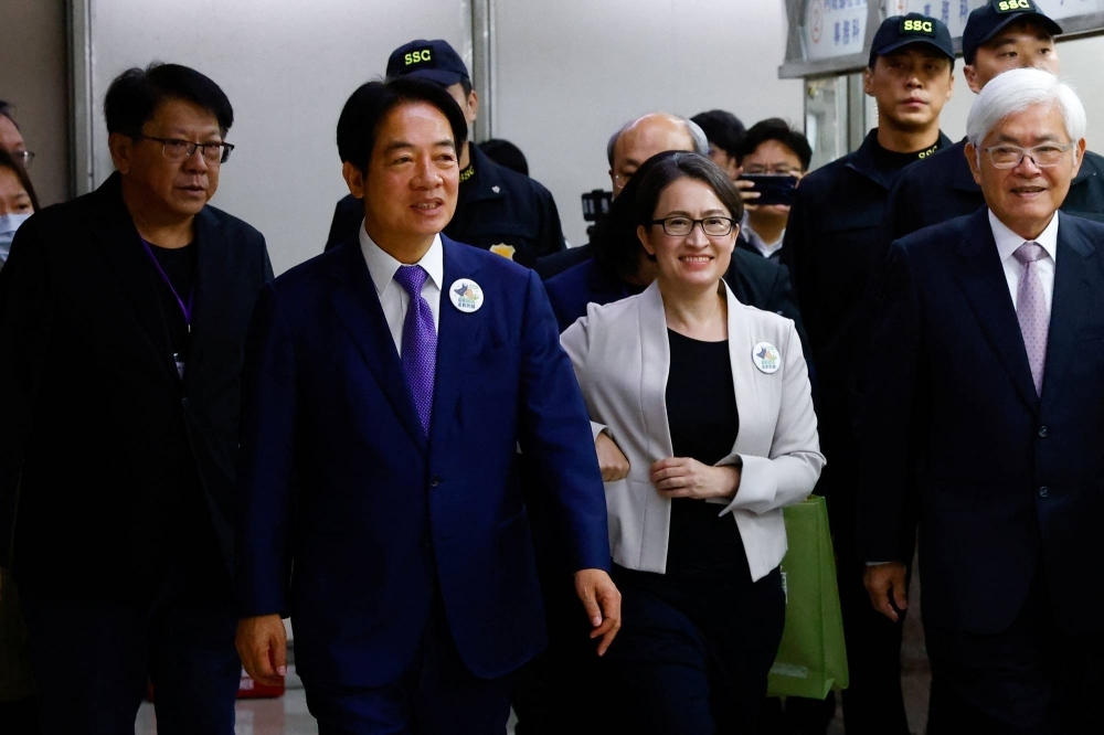 Taiwan's Vice President Lai Ching-te and his running mate Hsiao Bi-Khim arrive to register for the upcoming presidential election for the ruling Democratic Progressive Party (DPP) at the Central Election Commission in Taipei, on Tuesday. 